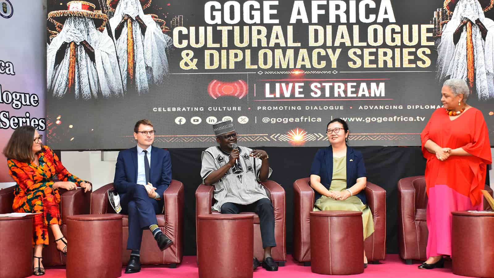Wide panel shot of diplomats seated in discussion