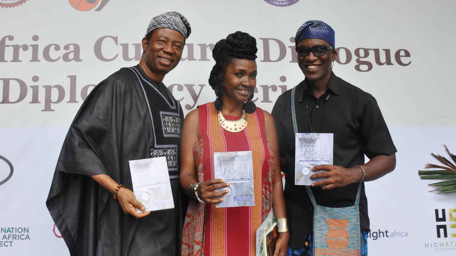 Traditional ruler or panelist posing with the book